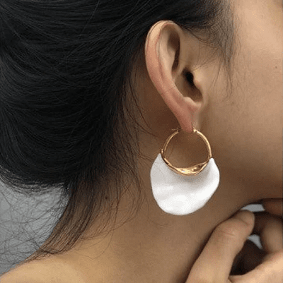 hoop earrings with large decorative white bit, described as avant garde by Etsy creator