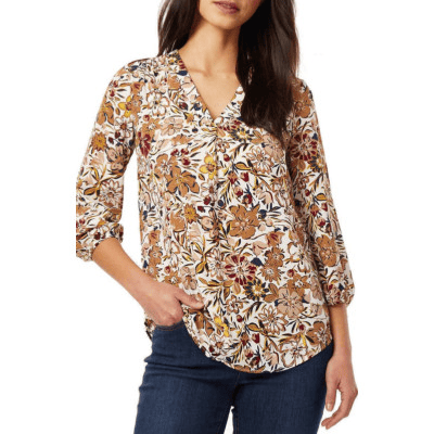 A woman wearing a brown print blouse and blue jeans