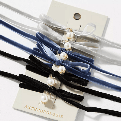 hair elastics made of velvet with a pre-tied bow with a pearl charm dangling from it