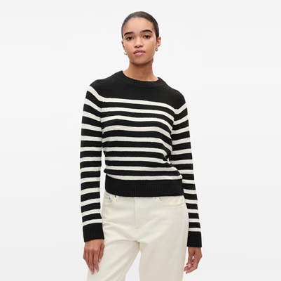 A woman wearing ivory pants and a black-and-white striped sweater