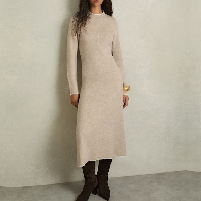 A woman wearing a gray knitted long dress and brown gamuza boots