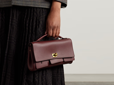woman holds small burgundy clutch