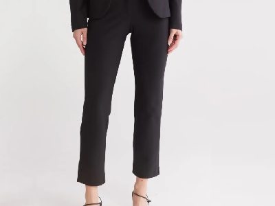 A woman wearing a white top inside with black blazer top and black trouser pants with sandals
