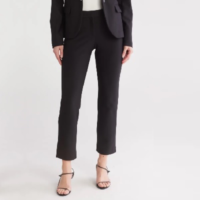 A woman wearing a white top inside with black blazer top and black trouser pants with sandals