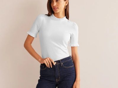 A woman wearing a white top and dark blue jeans