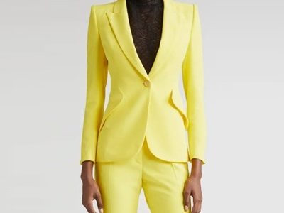 A woman wearing a yellow suit and black turtleneck
