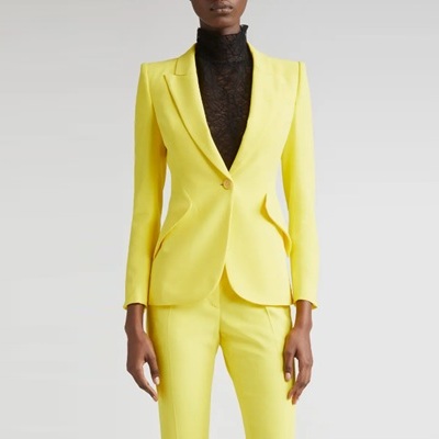 A woman wearing a yellow suit and black turtleneck
