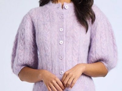 A woman wearing a purple cardigan jacket and denim pants