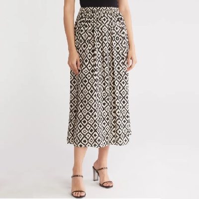 A woman wearing a printed midi skirt and open block sandals