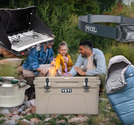 Family Sitting By A Fire Surrounded By Camping Gear