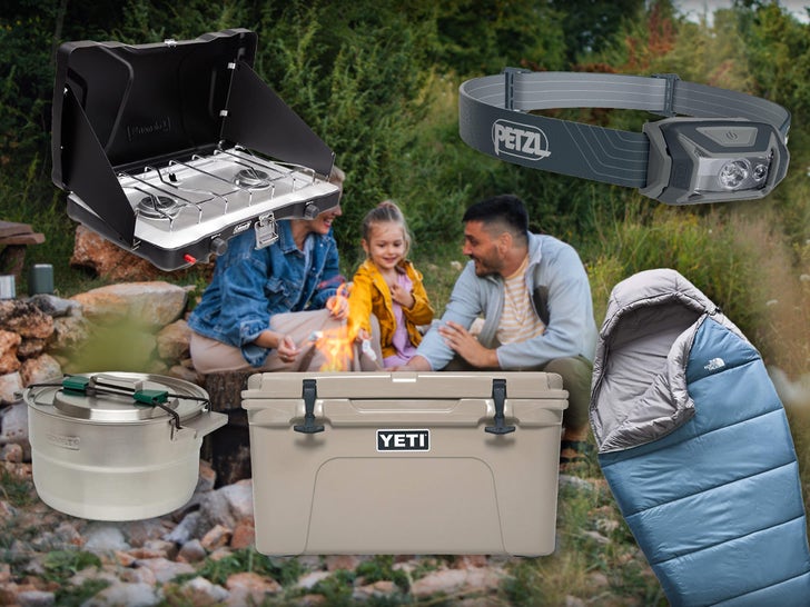 Family Sitting By A Fire Surrounded By Camping Gear