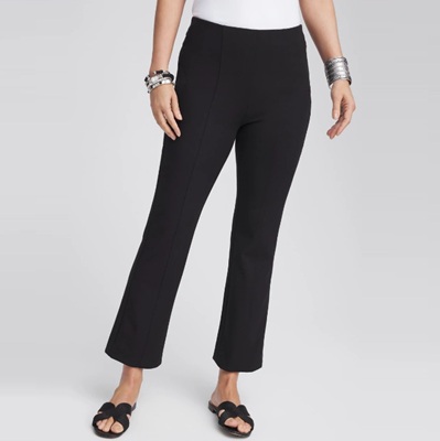 A woman wearing black cropped pants, a white top, black sandals, and silver bracelets