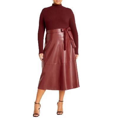 A woman wearing a maroon long sleeve turtleneck top and maroon leather skirt with red heels
