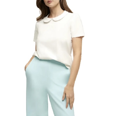 A woman wearing a white short sleeve Peter Pan collar top and baby blue pants