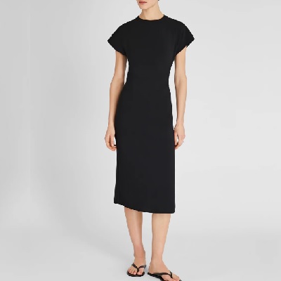 A woman wearing a black dress and black slippers