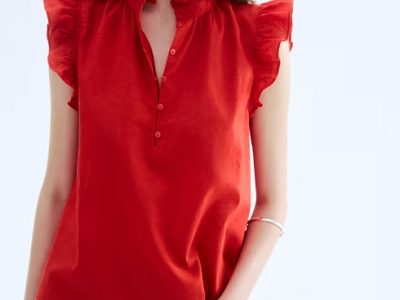 A woman wearing a red linen blouse and denim pants