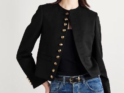 A woman wearing a black top with black twill jacket and denim pants