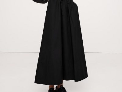 A woman wearing a black maxi skirt and black shoes
