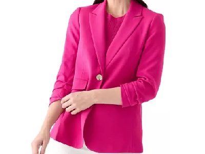 A woman wearing a pink blazer and white pants