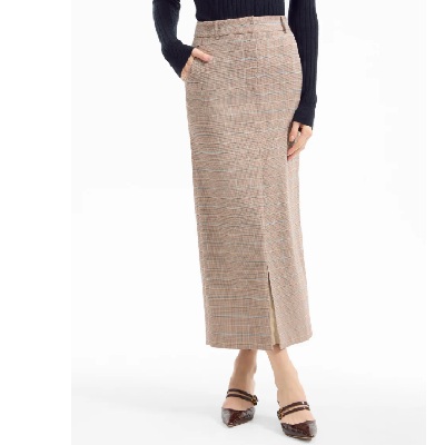 A woman wearing a brown plaid midi skirt with brown sandals and a black top