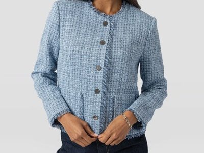 A woman wearing a light blue boucle jacket and dark blue jeans