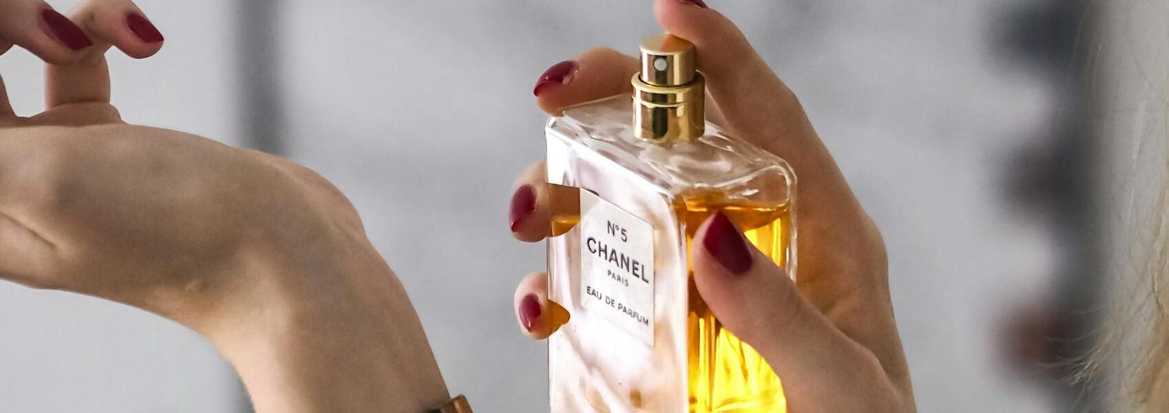 Close-up of a woman applying perfume on her wrist. Elegant and sophisticated.
