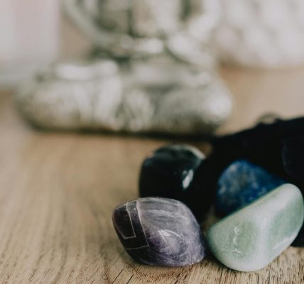 Serene Zen setup with healing crystals and a candle on a wooden table, promoting tranquility.