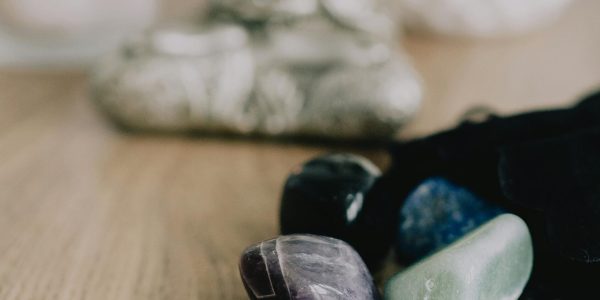 Serene Zen setup with healing crystals and a candle on a wooden table, promoting tranquility.