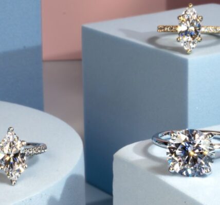 solitaire engagement rings in cushion, oval, and pear cut displayed on elevated blue boxes