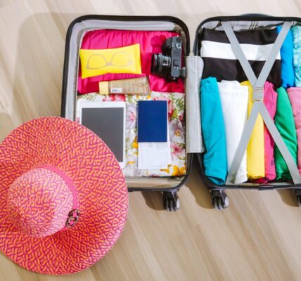 top view of a suitcase packed with clothes a camera and a sun hat ready for summer travel. 8212231 scaled e1783078111254