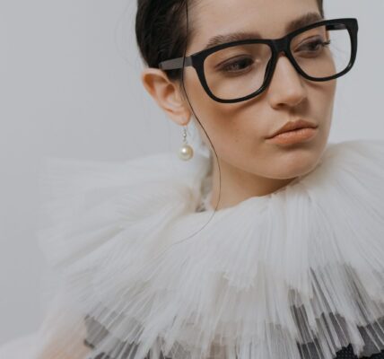 portrait of a stylish woman in a chiffon collar wearing glasses and a pearl earring. 6539156 scaled e1783420145984