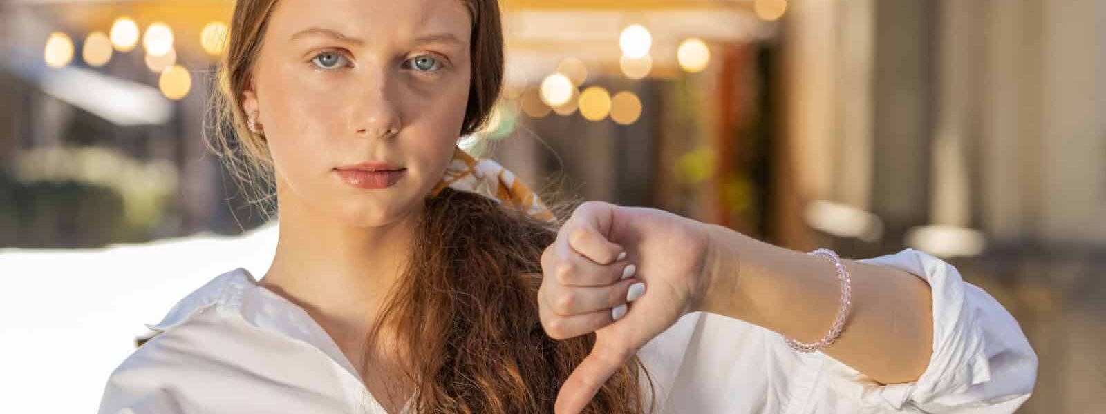 Disapproving teenager thumbs down. Image credit Andrii Iemelianenko via Shutterstock