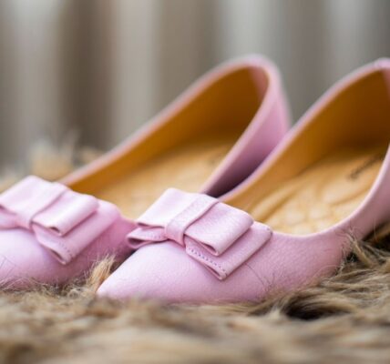 Elegant pink leather flats with bow detail on furry background, perfect for a chic footwear collection.