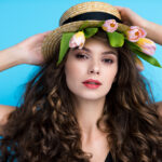Attractive young woman in canotier hat with pink tulip