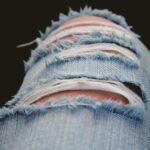 Detailed shot of torn denim jeans showcasing modern fashion and style.