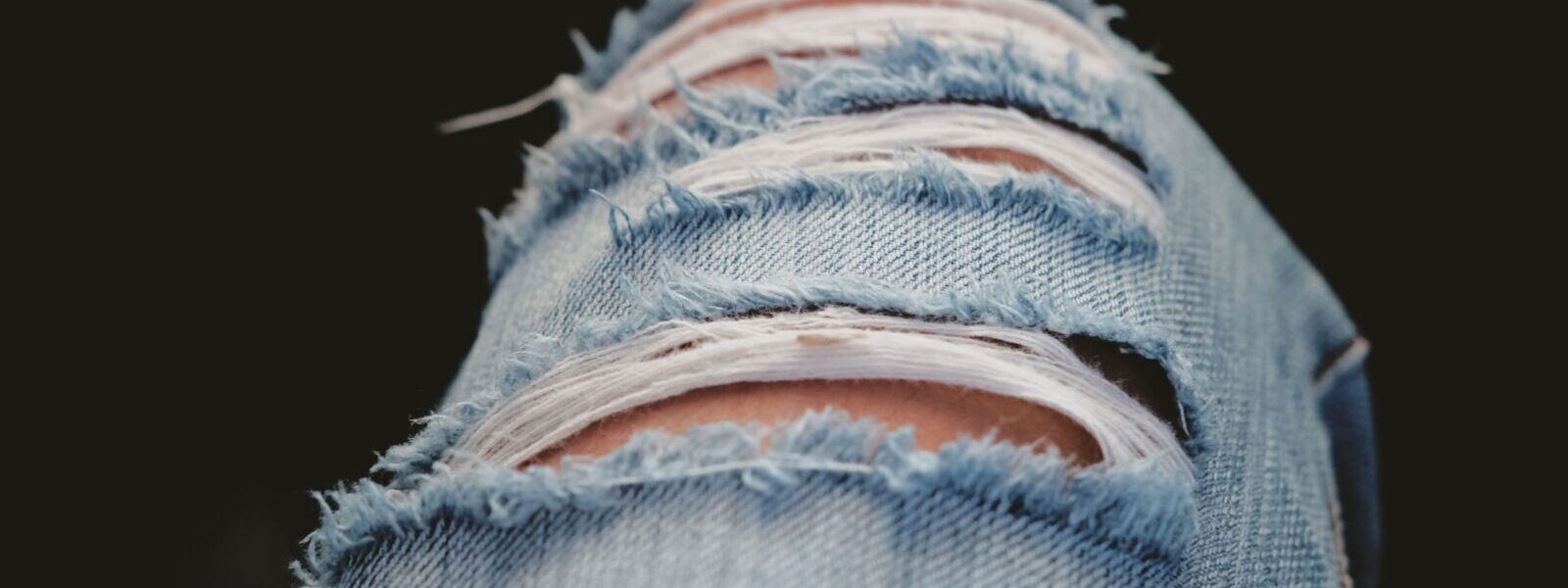 Detailed shot of torn denim jeans showcasing modern fashion and style.