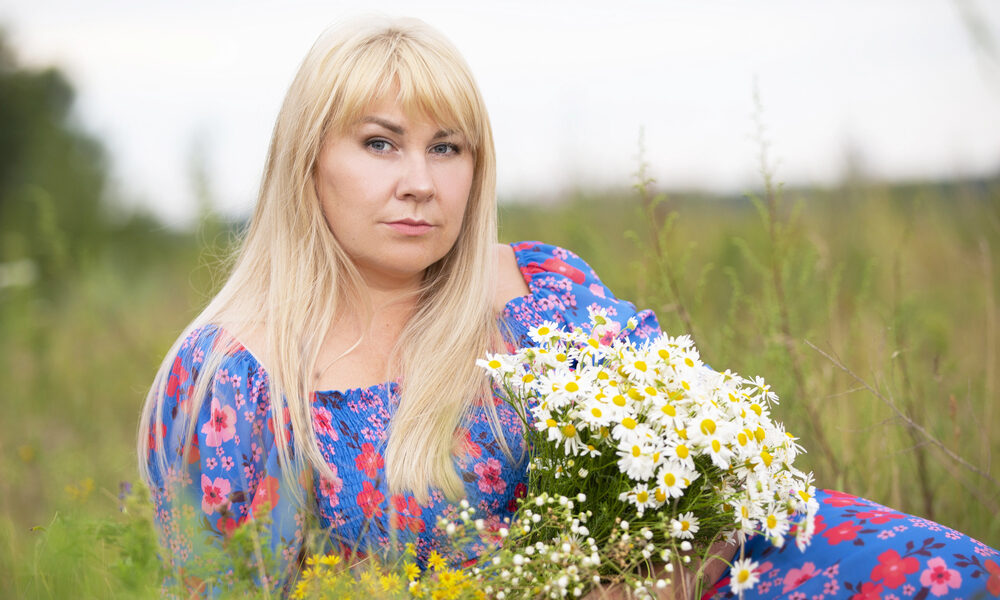 A beautiful plus size girl with white hair in a summer dress