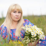 A beautiful plus size girl with white hair in a summer dress