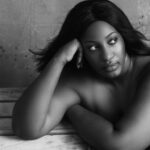 Black and white high angle of plump African American female with flowing hair thinking on problem and looking away